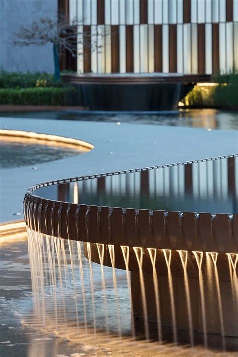 A Fountain With Water Spouting From It S Sides In Front Of A Building