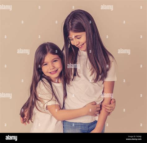 Cute Portrait Of Two Cheerful Siblings Girls Sisters Having Fun