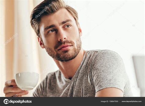 Handsome Man Drinking Coffee At Home Stock Photo By ©arturverkhovetskiy