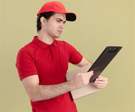 Hombre De Entrega Cauc Sico Joven Confuso En Uniforme Rojo Y Gorra