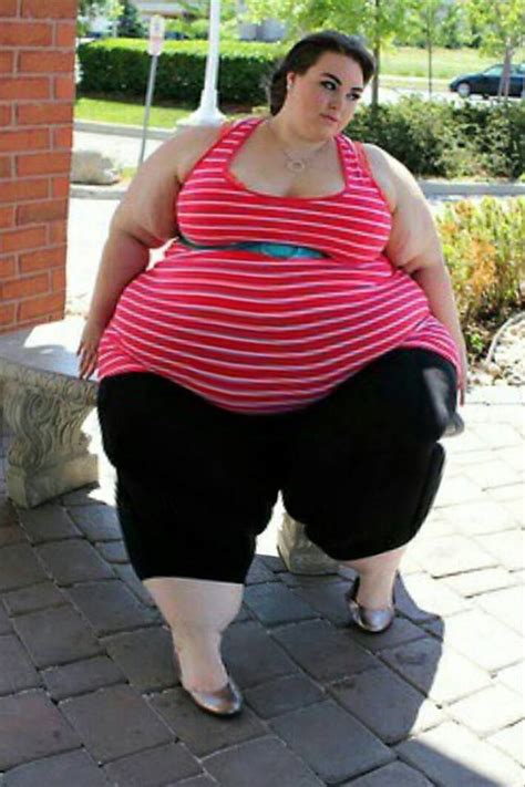 A Woman In Red And White Striped Shirt Standing On Brick Walkway With