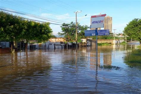 A Flooded Street With Signs And Buildings In The Background