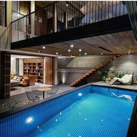 An Indoor Swimming Pool With Stairs Leading Up To The Second Floor And