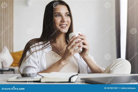 Schöne Brunette Mädchen Sitzt am Tisch Vor Dem Laptop Und Hält Eine Tasse Kaffee Mit Ihren