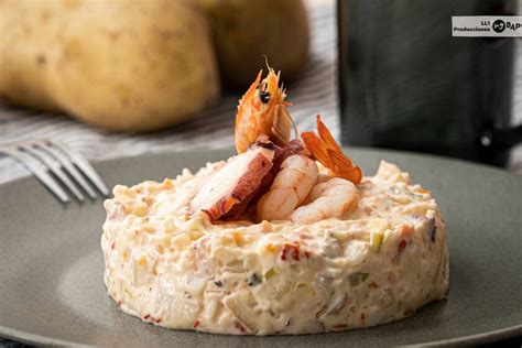 A Plate With Food On It And Two Potatoes In The Background