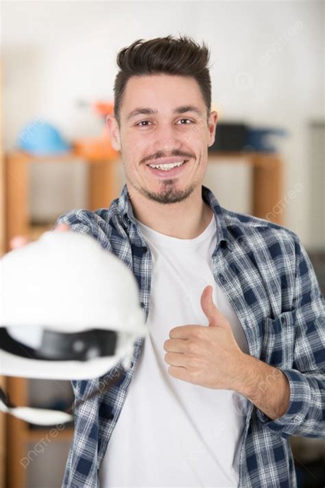 Fondo Hombre Sosteniendo Un Casco Y Haciendo Un Gesto De Pulgar Hacia