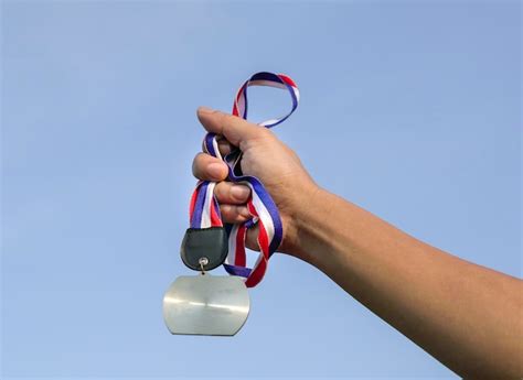 M O De Homem Levantada Segurando Uma Medalha Contra O C U Foto Premium