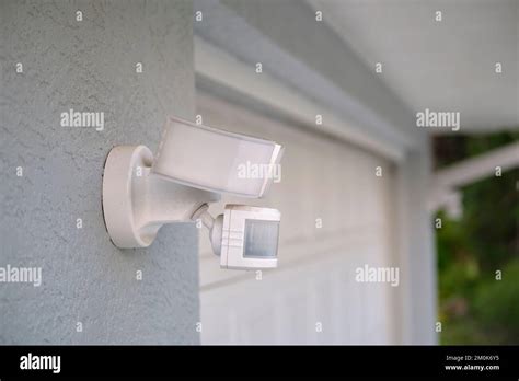 Motion Sensor With Light Detector Mounted On Exterior Wall Of Private