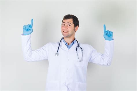 Free Photo Male Doctor In White Coat Gloves Pointing Fingers Up And