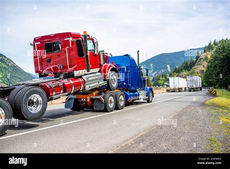 Powerful Blue Big Rig Semi Truck Transporting Another Semi Truck