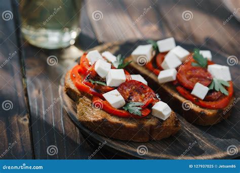 Crostini Con Los Tomates Y El Queso Feta Asados A La Parrilla Imagen De