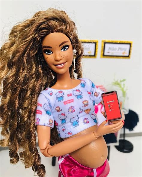 A Doll Holding A Cell Phone In Her Hand