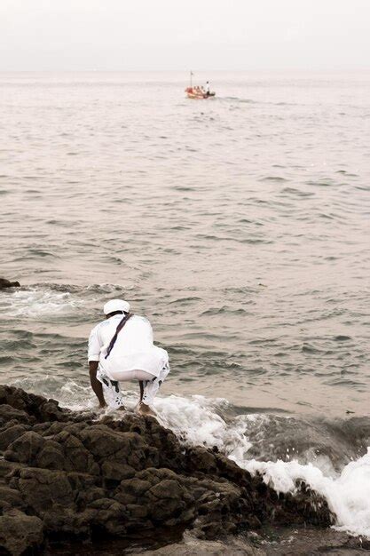 Los admiradores del candomblé se ven en lo alto de una roca en la playa