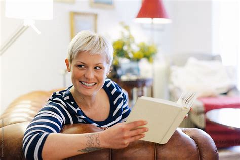 «beautiful Blonde Woman Reading A Book On The Couch At Home Del