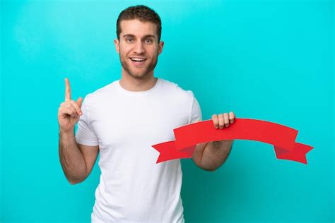 Jovem Homem Caucasiano Isolado Em Fundo Azul Segurando Um Cartaz Vazio