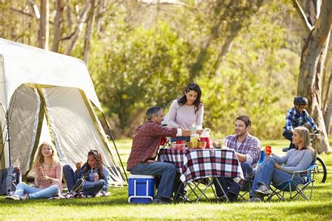 Two Families Enjoying Camping Holiday In Countryside Stock Photo By