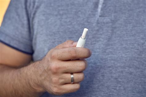 Tecnologia de cigarros eletrônicos iqos close up de um homem fumando