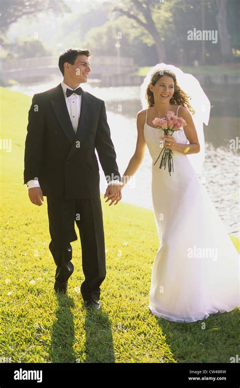 Newlywed Couple Walking Together Holding Hands Stock Photo Alamy