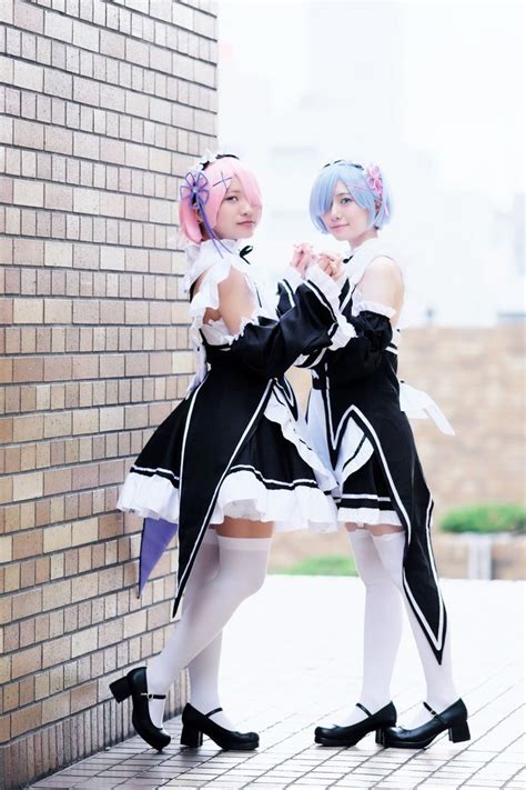 two young women dressed in black and white outfits standing next to a ...