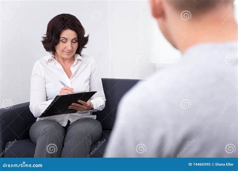 Friendly Female Psychiatrist Working With Her Patient In Office Stock