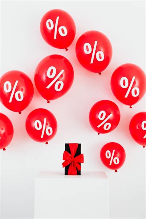 A Gift With Red Ribbon in Between Red Balloons With Percentage Symbols ...