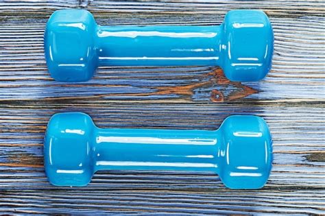 Premium Photo Blue Fitness Dumbbells On Vintage Wooden Board