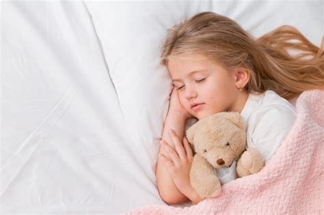 Retrato De Una Ni A Rubia Durmiendo En Una Cama Con Un Oso De Peluche