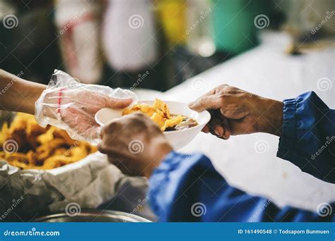 Volunteers Scooping The Food To Share With The Needy Concept Of