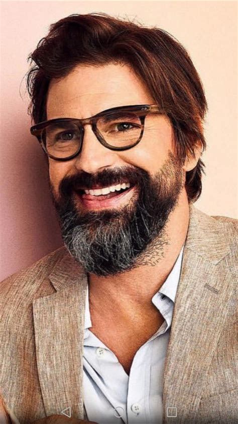 A Man With Glasses And A Beard Smiling