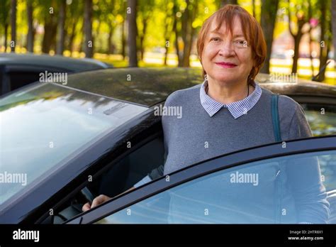 Positive Mature Woman Standing Beside Her Car Stock Photo Alamy