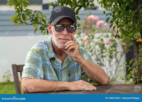 Hombre Mayor En La Gorra De B Isbol Con Gafas De Sol Relaj Ndose En