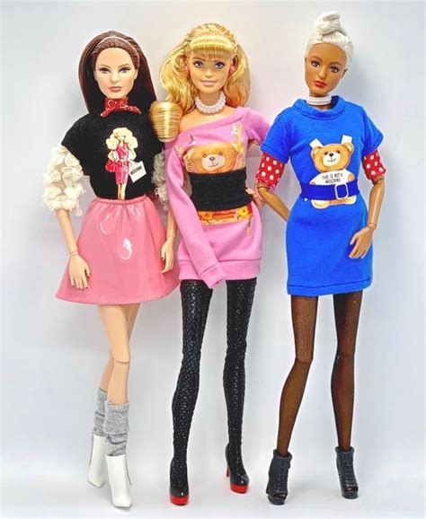 Three Barbie Dolls Standing Next To Each Other