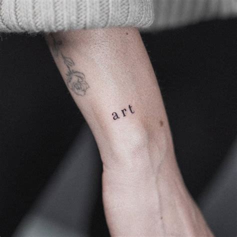 Word "art" tattooed on the wrist.