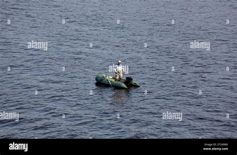 Mature Man Fishing On The Lake From Rubber Inflatable Boat Fishing On