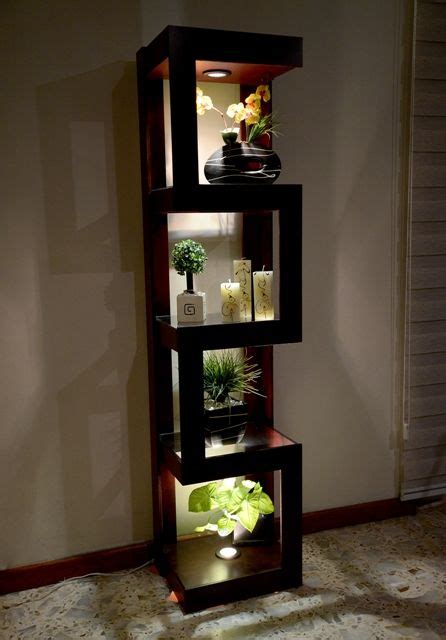 A Tall Shelf With Plants In It On Top Of A Carpeted Floor Next To A Wall