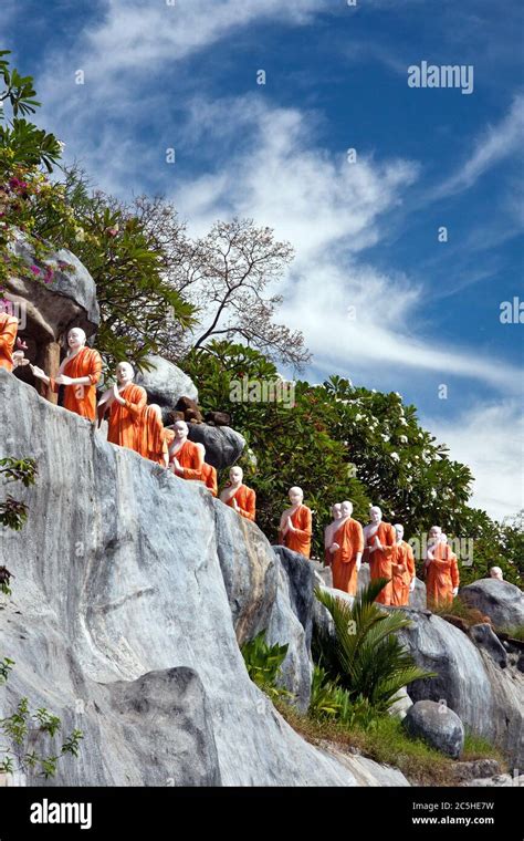 Statues Of Buddhist Monks Queuing To Take Lotus Flower Offerings To