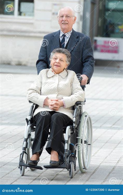 Senior Man Pushing Woman In Wheelchair Stock Photo Image Of Beautiful