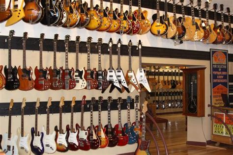 The Guitars Are Hanging On The Wall In The Music Store S Guitar Shop Area