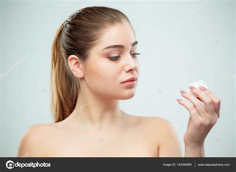 Portrait Of Young Beautiful Woman Applying Moisturizing Cream On Her