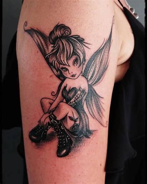 A Woman With A Tattoo On Her Arm Has A Fairy Tinkerbell Sitting On Top