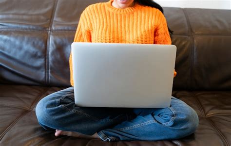 Premium Photo Faceless Woman Using Computer On The Sofa At Home