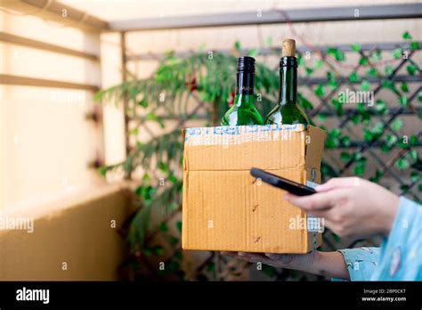 Young Indian Girl Carrying A Cardboard Box Of Alcohol Liquor That Has