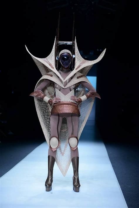 A Woman Is Walking Down The Runway In An Unusual Costume