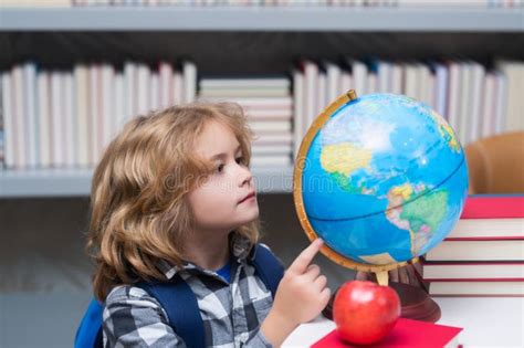 Alunno Che Guarda Il Globo Nella Biblioteca Della Scuola Elementare