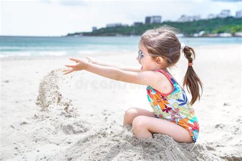 Little Cute Girl Playing In The Sand On The Beach By The Sea Stock