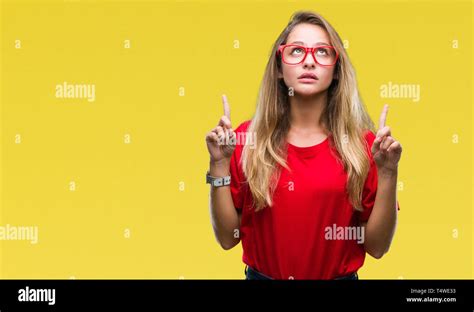 Junge hübsche blonde Frau Brille über isolierte Hintergrund erstaunt