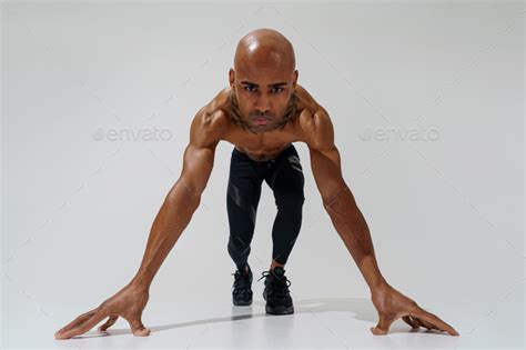 Bottom View Of Sportsman With Naked Torso Is Warming Up On White Studio