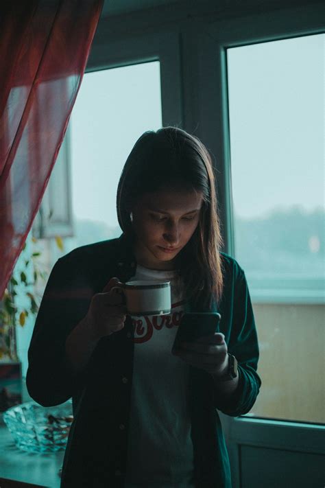 Femme En Veste Noire Tenant Une Tasse En Céramique Blanche Photo