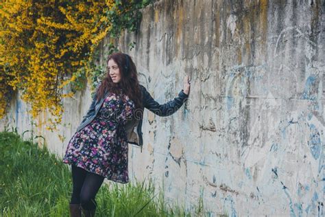 Pretty Girl With Long Hair Leaning Against A Concrete Wall Stock Photo