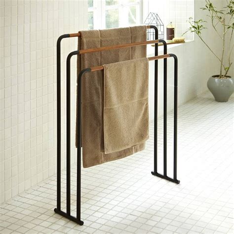 A Towel Rack With Two Towels Hanging From It S Sides In A White Tiled